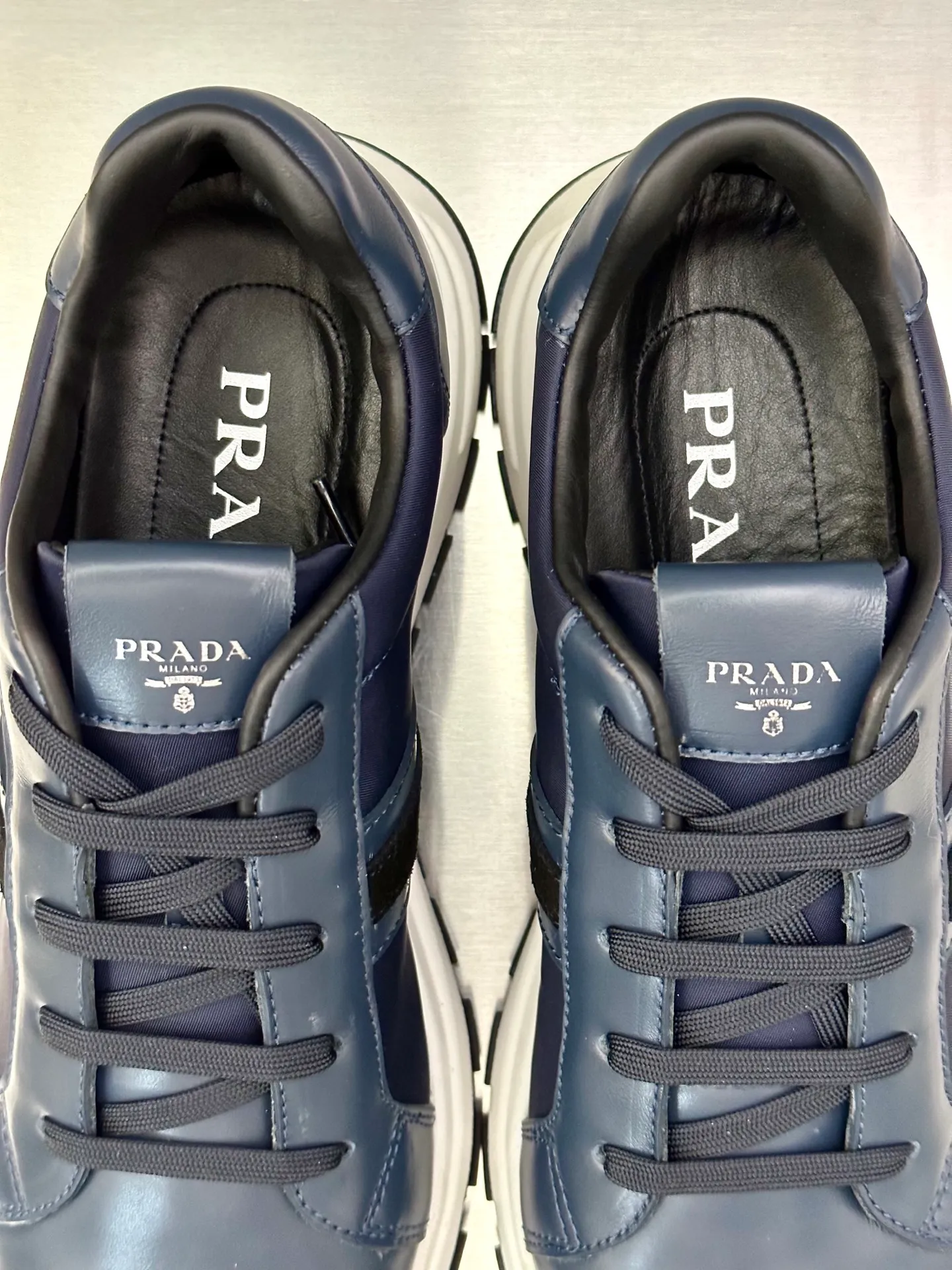 💰740 Prada/Prada men's new mesh stitching sneakers. This sneaker presents a modern version, reinterpreting the brand's archive style with clean lines and smooth details. The shoes are made of calf leather and technical fabric, with a triangular metal logo on the outside, bright TPU decoration on the heel, and a longer and padded inner heel design for a more comfortable fit. The tongue is decorated with a silk-screen logo, and is paired with a hollow rubber sole on the heel. The full cowhide lining comes standard with logo cowhide foot pads, making the upper foot taller, more comfortable, and versatile! Comes with full original packaging! Size: 39-40-41-42-43-44 standard leather shoe size (45 can be customized and does not support returns)